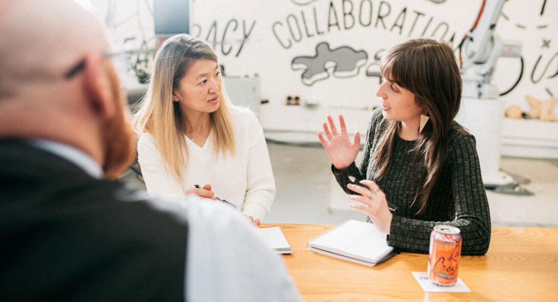 Loupe team and Kinesis team conversing at a desk