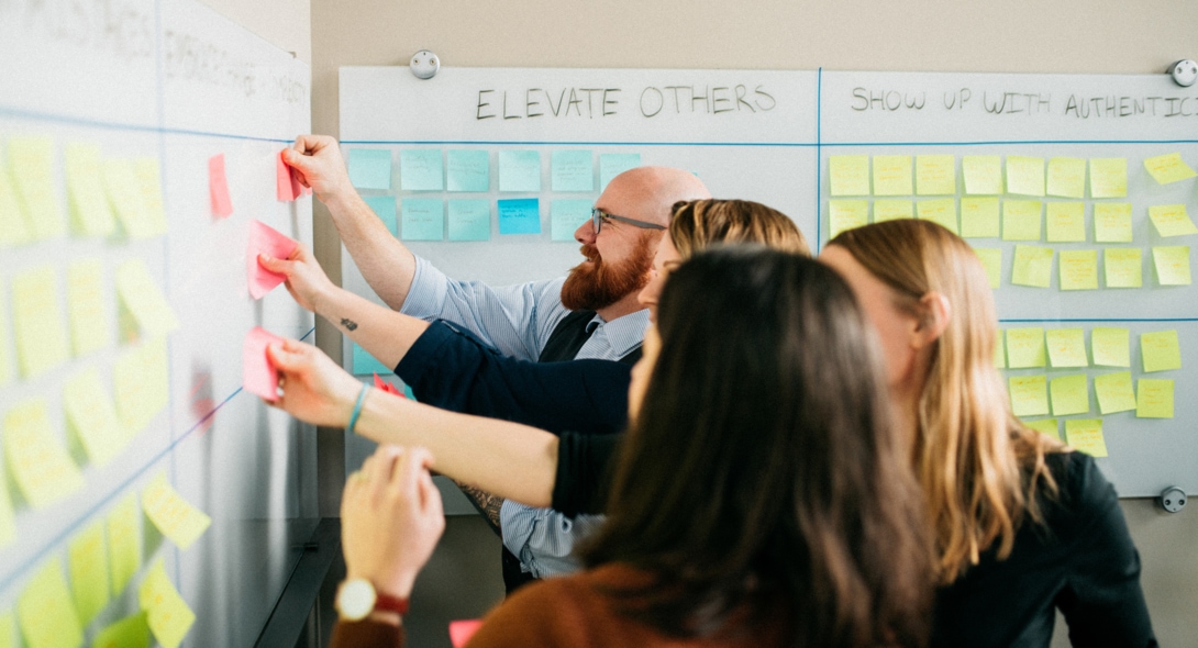 kinesis staff facilitating proprietary way exercise with post its on whiteboards