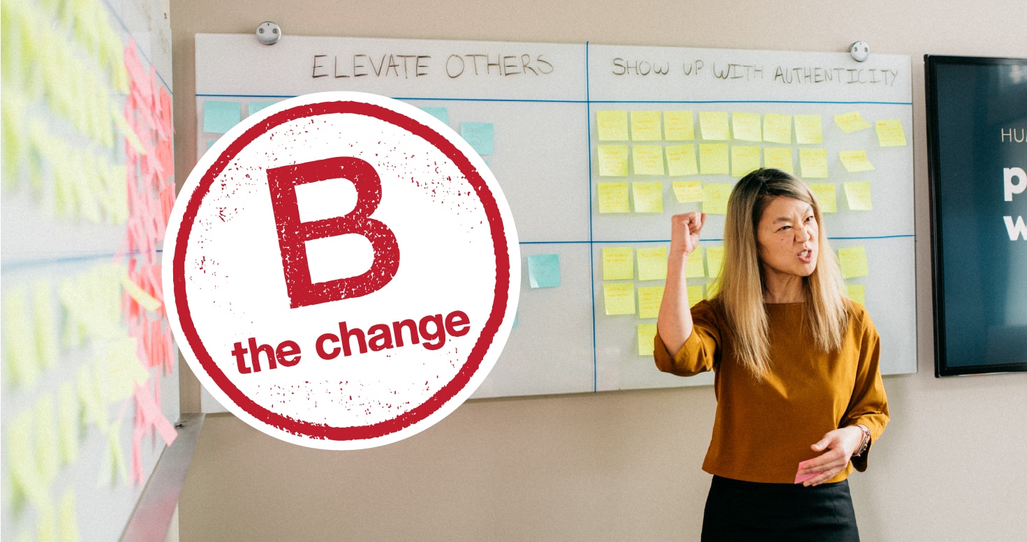 Woman stands in front of white board filled with Post-It Notes