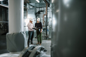 Two Systems West team members looking at a binder inside a building