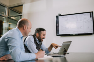 Two Systems West employees collaborating on a laptop