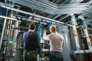 Two Systems West employees pointing at and discussing building interior structure