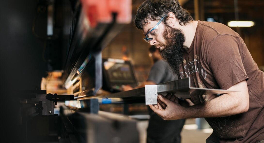 Solid Form employee cutting a beam