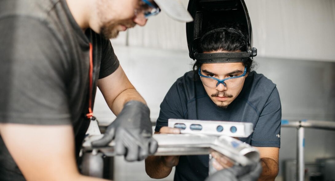 Two Solid Form employees leveling material in workshop