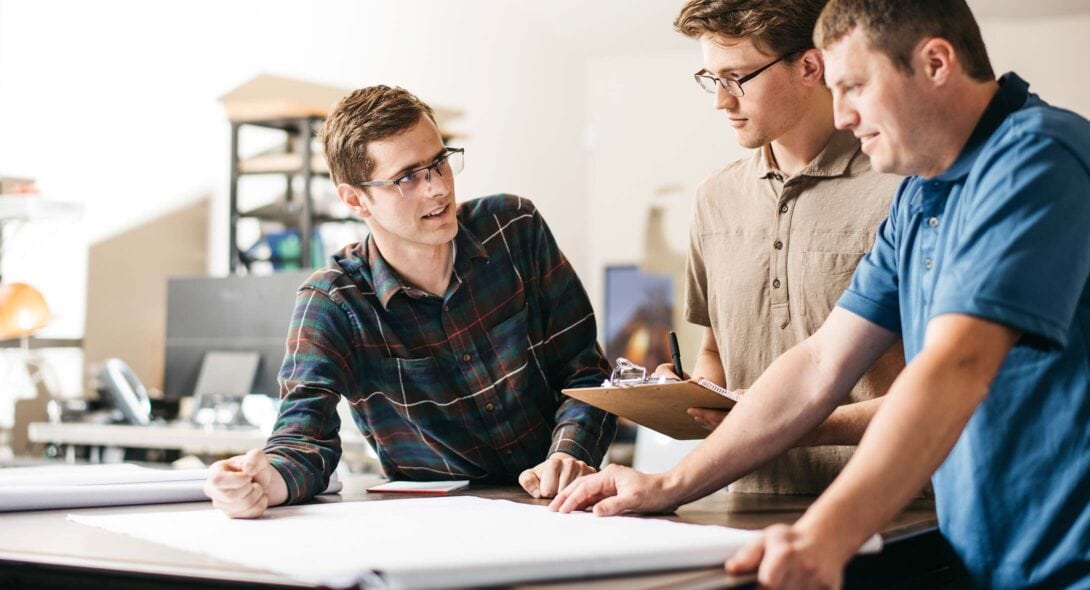 Two Solid Form engineers working together over blueprint plans