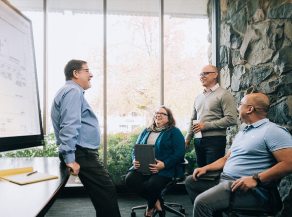 Systems West team conversing in office space