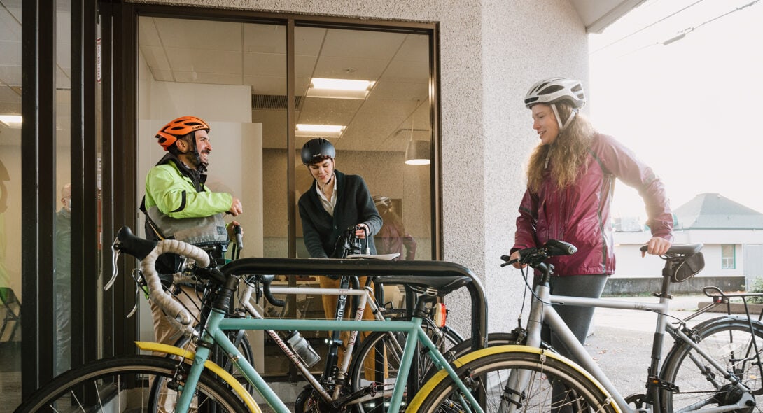 Systems West team members with their bicycles chatting outside the office
