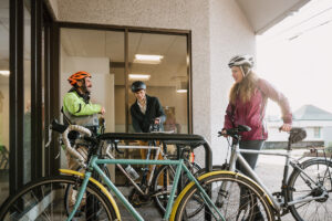Systems West team members with their bicycles chatting outside the office