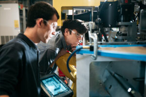 Two team members in deep work over a machine